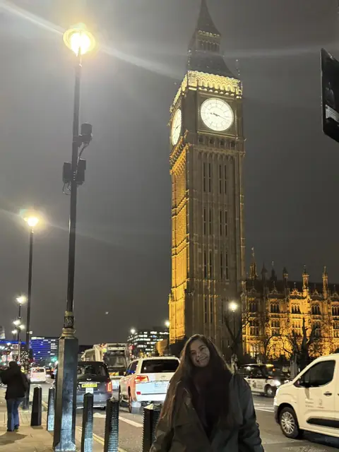 Nathália sorrindo diante do Big Ben, em Londres, à noite